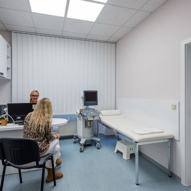 Praxisraum mit Patientin und Mediziner