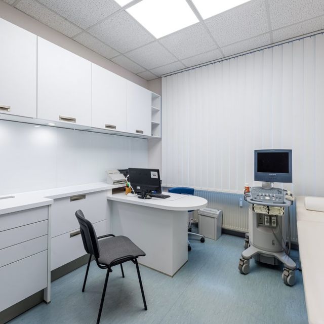 Untersuchungsraum mit Schreibtisch, Stuhl und Liege